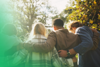 Teens walking arm and arm with fall leaves in the background