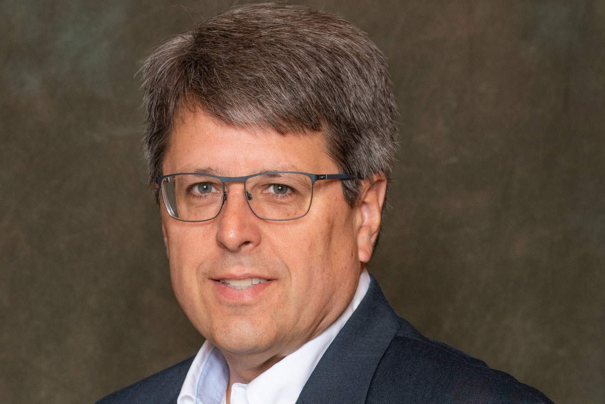 Dr. John Clements in front of brown background