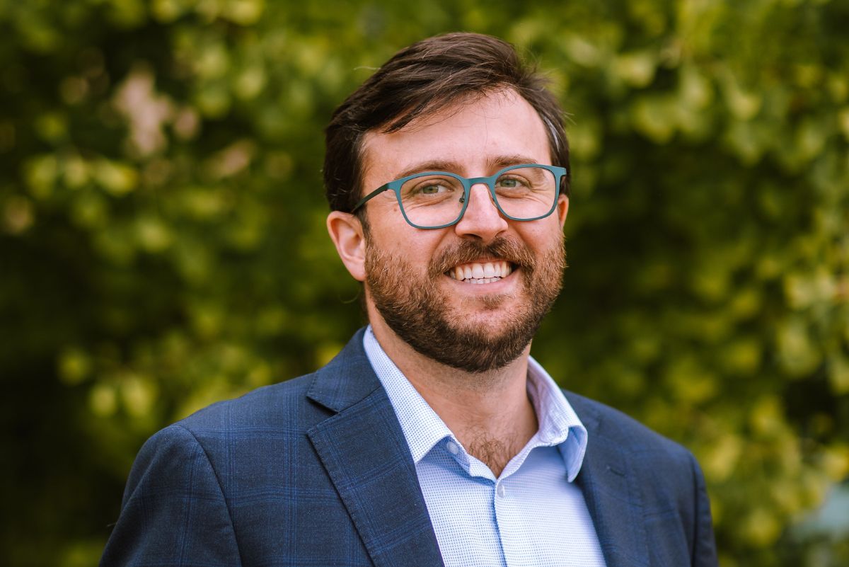 Dr. Eric Finegood in front of green trees