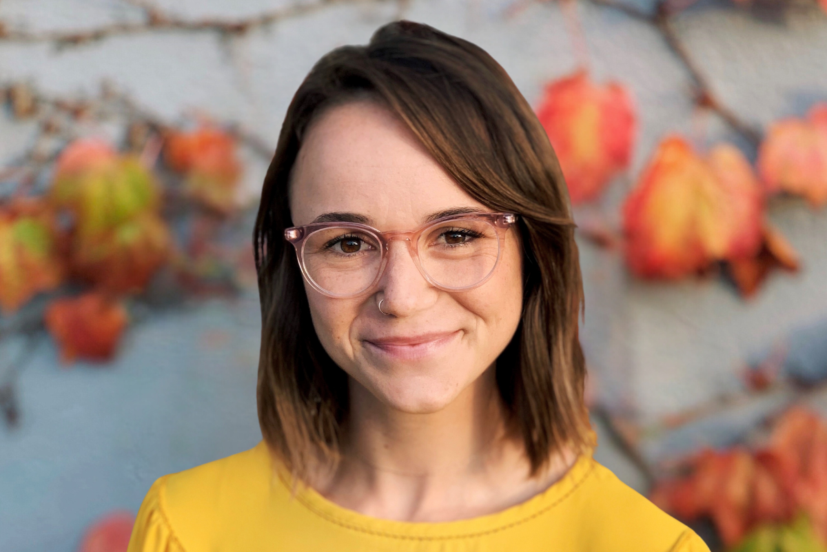 Dr. Samantha Gailey in front of wall with orange leaves