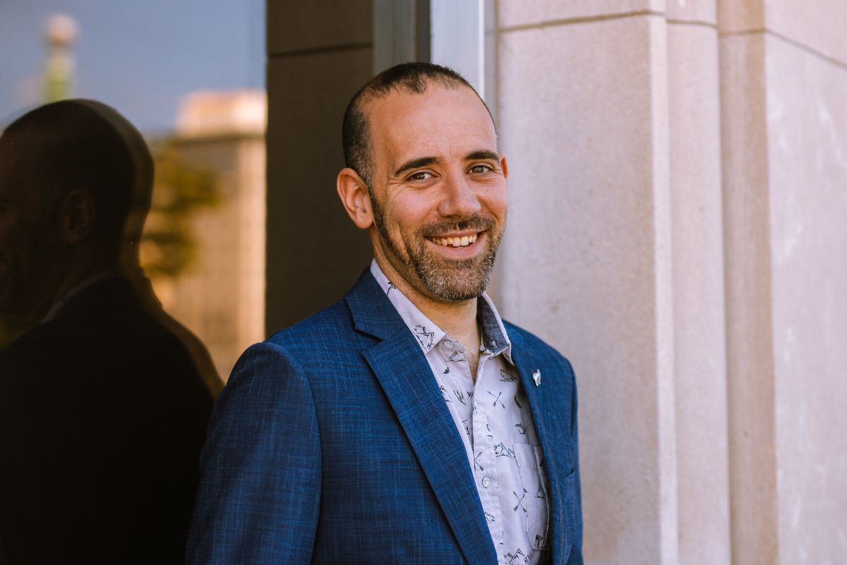 Dr. Dick Sadler in front of large glass window outside of building