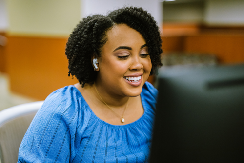 MPH student in front of computer wearing headphones during meeting