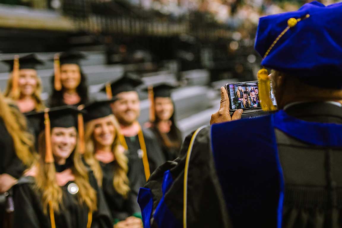 Professor takes photo of graduating students