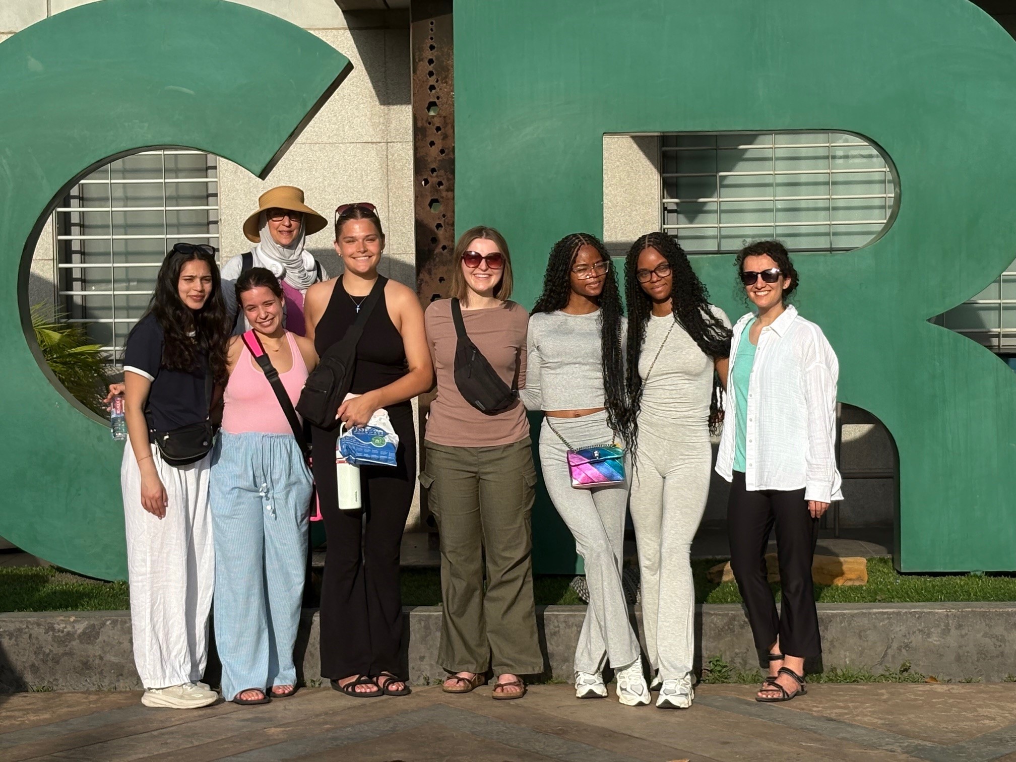 MPH Students standing in front of Accra, Ghana airport sign